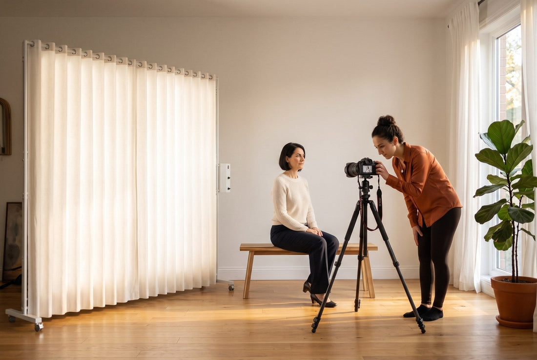 Photographer checking her camera while a seated client is lit by a LEDWindow PRO window-style continuous light, with real daylight coming through a window in a bright home studio