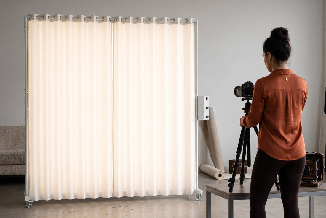 Lucy, a photographer, adjusting a camera tripod in front of a glowing LEDWindow PRO window-style LED light in a studio