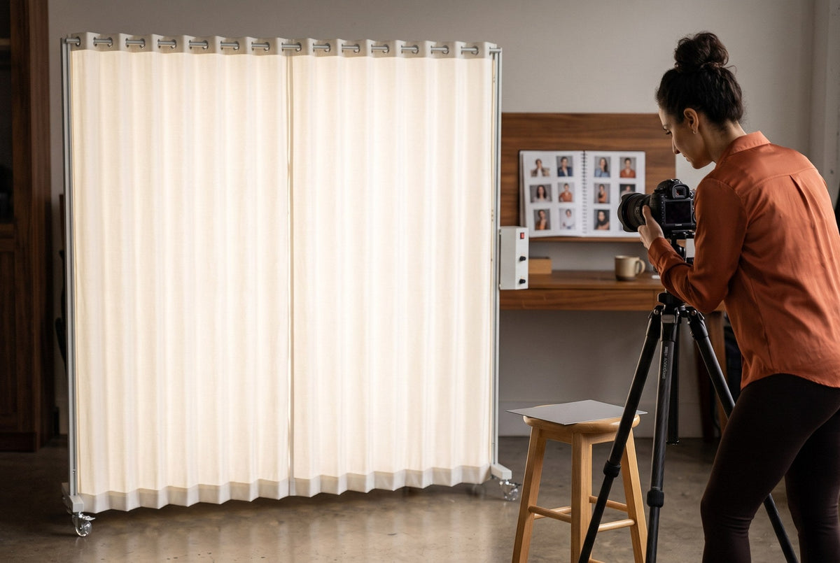 Lucy, a photographer, adjusting her camera on a tripod beside a neutral gray card in front of a softly glowing LEDWindow PRO panel for a consistent portrait color workflow